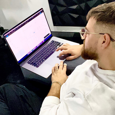 Matthias auf dem Sofa sitzend mit Macbook und arbeitet